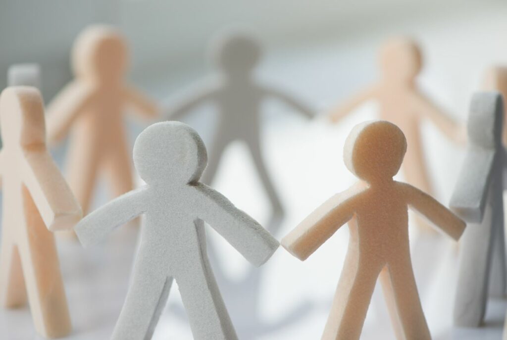 Paper cut out people holding hands